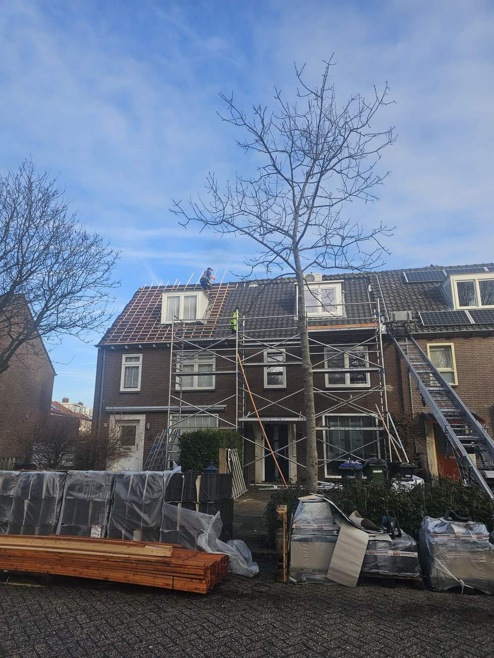 Werk in uitvoering: materiaal op straat, dak op de lat